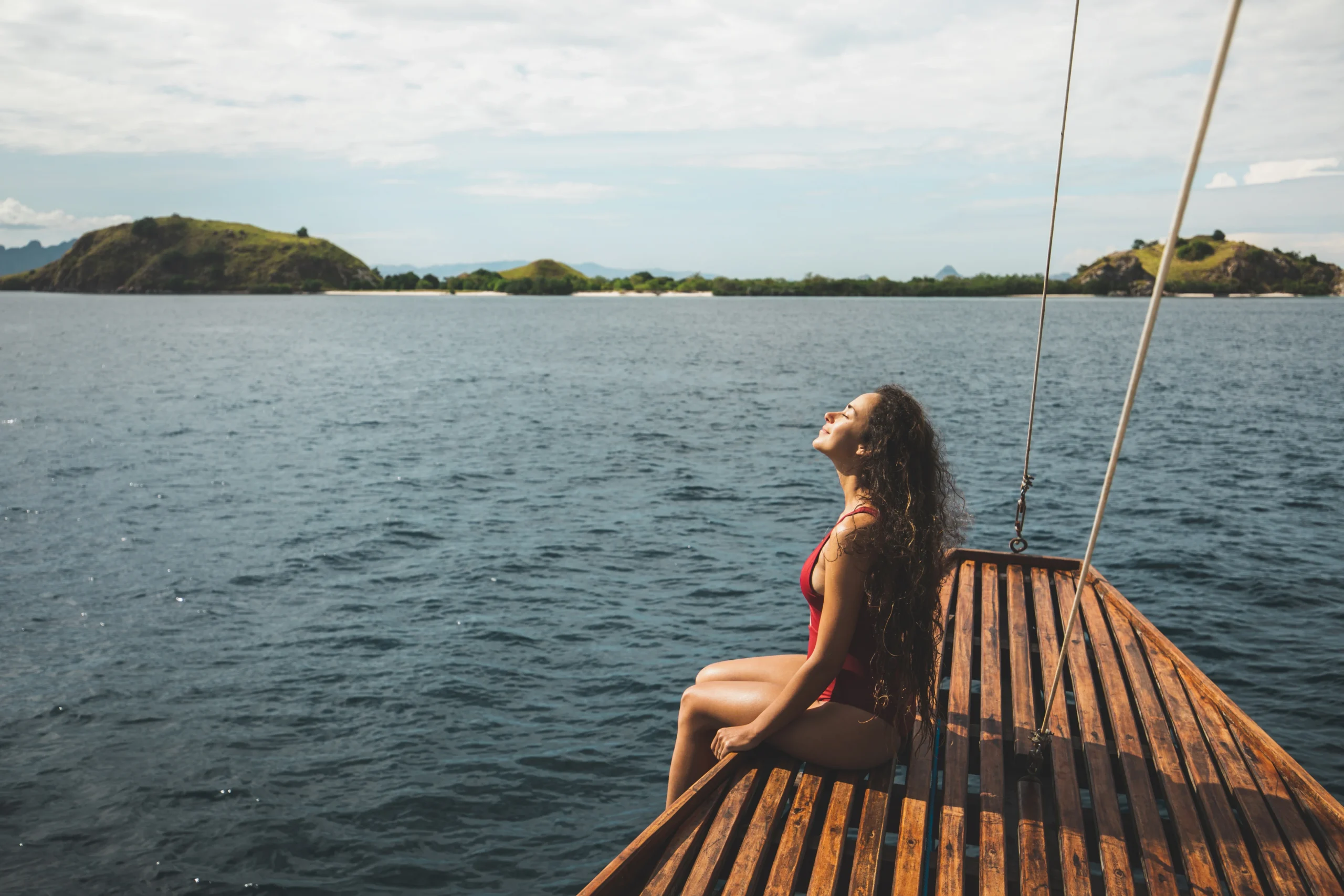 woman in red swimsuit relaxing on a boat - The Ultimate Guide for Solo Travelers in Galapagos: Luxury Without Compromise - Luxury Cruises